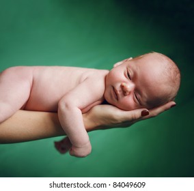 Beautiful New Born Baby Resting On Mom's Hand.