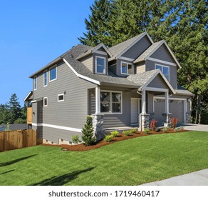 Beautiful New Home Exterior With Two Car Garage And Covered Porch On Sunny Day