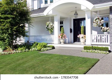 Beautiful New Luxury Home Exterior In Summer. Custom House With A Porch And Professional Landscaping In Canada. 