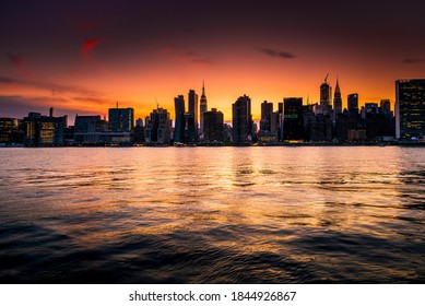 Beautiful New York city skyline silhouette during a orange and warm sunset evening