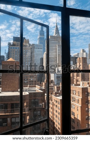 Beautiful New York City summer cityscape with blue sky seen through a vintage open window. Chrysler Building visible, with copy space.