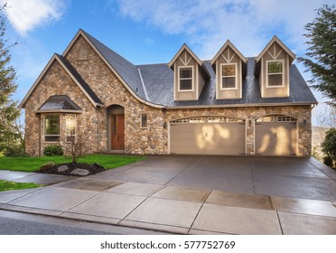 Beautiful, Newly Built Luxury Home Exterior With Stone Facade And Three Car Garage, And Gables