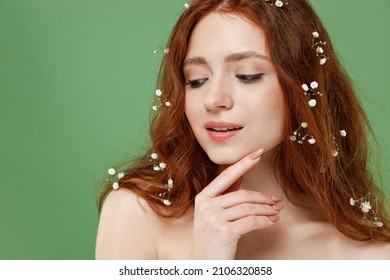 Beautiful nice caucasian half naked topless redhead hair woman 20s with nude make up touch face look aside isolated on pastel green color background Skin care healthcare cosmetic procedures concept
