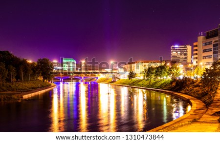 Beautiful night landscape - a river with houses on the beach in the city