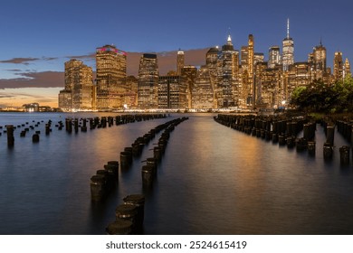 Beautiful Night Light and Lower Manhattan skyline with East River and New York City. Twilight with Reflections and Abandoned Pier at Sunset from Brooklyn Bridge Park - Powered by Shutterstock