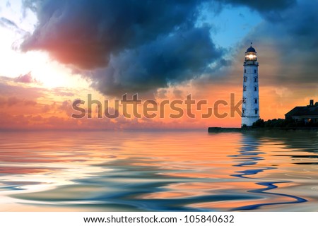Beautiful nightly seascape with lighthouse and moody sky at the sunset