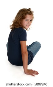 Beautiful Nine Year Old Caucasian Girl Sitting On White Floor.