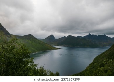 Beautiful Norwegian fjord landscape. On the background Fjordgard village and famous Segla mountain. Fish farms on the sea.