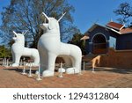 a beautiful objects lion like shape standing in front of house give more attraction for the tourist.a clear blue sky give more value to this picture.