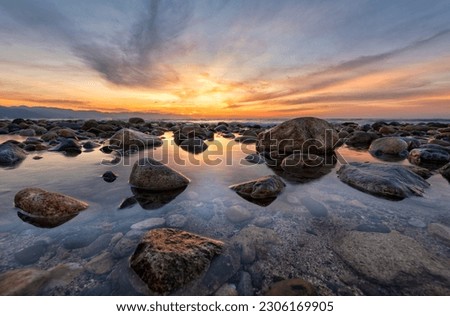 A Beautiful Ocean Sunset With Sea Rocks Sitting In A Tide Pool High Resolution