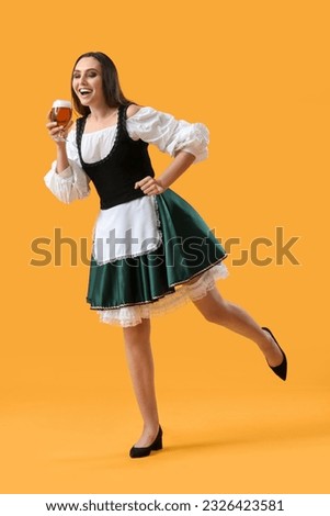 Beautiful Octoberfest waitress with beer dancing on yellow background Foto stock © 