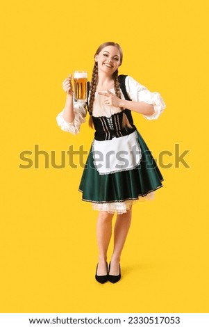 Beautiful Octoberfest waitress pointing at beer on yellow background Foto stock © 