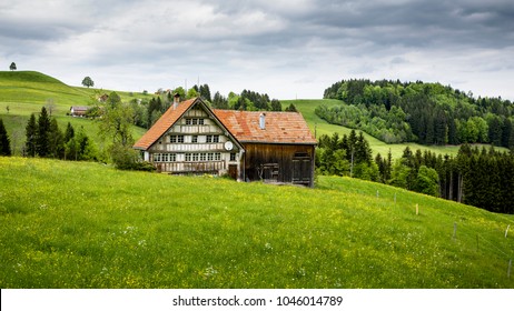 Beautiful old farm house midst the Swiss alps with a beautiful gras and sky landscape