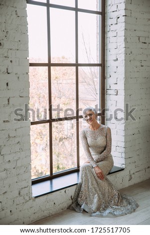 Similar – junge schöne Dame, die im Wohnzimmer neben einem Fenster posiert.