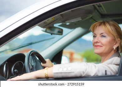 Beautiful Old Happy Elderly Driver Woman 55-60 Years In Jacket Driving A Car