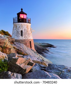 Beautiful old lighthouse on rocks at sunset