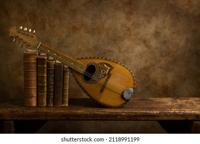 Beautiful old lute and antique books on a rustic old wooden shelf. 