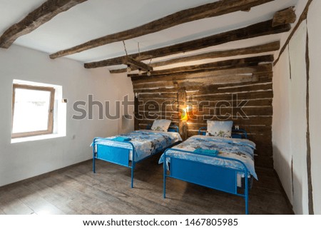 Beautiful old vintage country house - bedroom interior with wood beam ceiling and blue duvets and sheets
