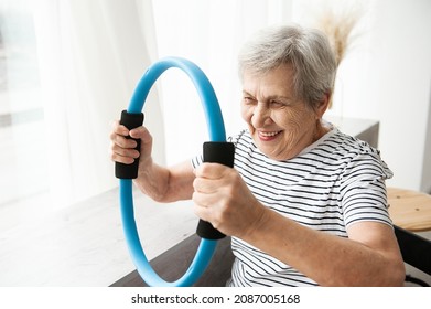 A beautiful old woman is doing exercises at home. The concept of physical exercises for the elderly.
