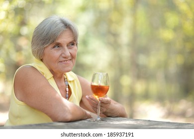 Beautiful Old Woman Drinking Wine In Nature