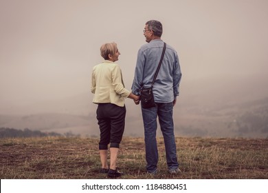 Beautiful Older Couple On Mountain Top Surrounded With Fog