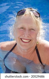 A Beautiful Older Woman Relaxes In Swimming Pool During Her Vacation