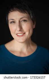 Beautiful Older Woman With Short Brown Hair And Eyes On A Black Background.