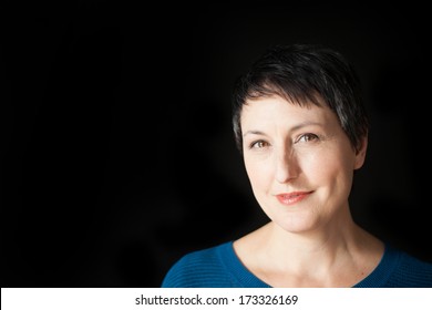 Beautiful Older Woman With Short Brown Hair And Eyes On A Black Background.