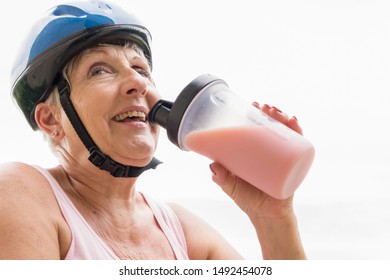 Beautiful Older Woman With White Hair And Blue Helmet Drinking Protein Shake 