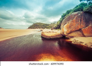 Beautiful orange rocks and brown water of Tidal River. Wilsons Promontory, Victoria, Australia - Shutterstock ID 609974390