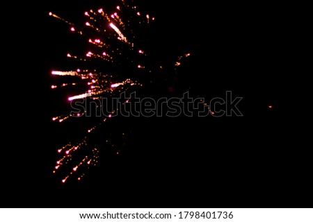 Beautiful orange single exploding firework against black sky background on new years eve