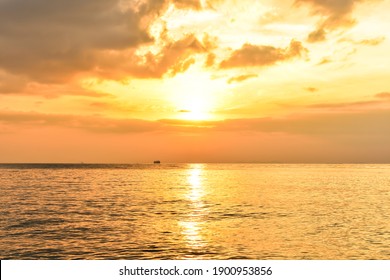 beautiful orange sunset in the bright sky over the calm sea with sunlight reflection at beachfront of Lipa Noi beach, Samui Island, Thailand. Seascape in the evening. Selected focus.