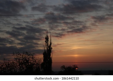 Beautiful Orange Sunset. Moody Dark Clouds In Autumn Sky. Tree Sillhouette.