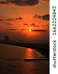 Beautiful orange sunset with view on an island and a highrise building, Abu Dhabi, UAE