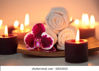 Beautiful orchid, towels and  burning candles