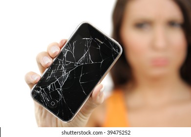 Beautiful, out of focus, young woman with troubled expression holding out her broken touch screen mobile phone