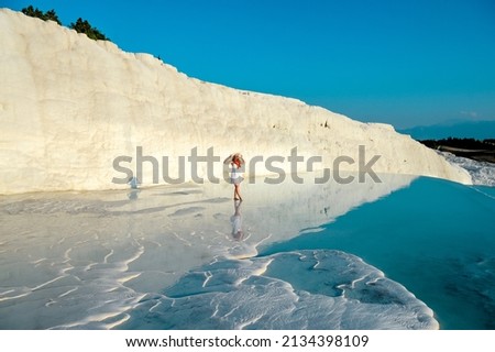 Beautiful outdoor hot spring pool. Natural travertine pools and terraces in Pamukkale. Cotton castle in southwestern Turkey, girl in white dress with hat natural pool Pamukkale.