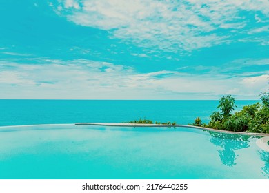 Beautiful Outdoor Infinity Swimming Pool In Hotel Resort With Sea Ocean View And White Cloud Blue Sky For Holiday Vacation And Travel