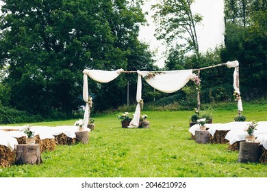 A Beautiful Outdoor Wedding Altar In Nature With Wooden Log Seats On A Sunny Day
