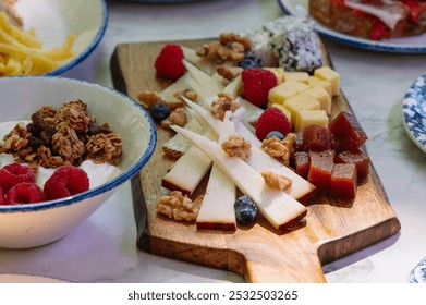 A beautiful overhead shot of a wooden cheese board featuring an assortment of cheeses, - Powered by Shutterstock