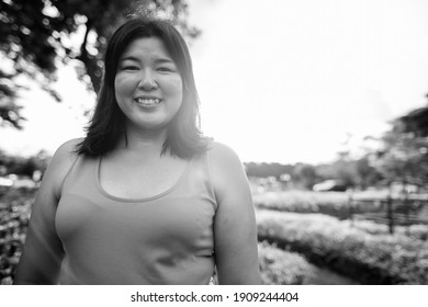 Beautiful overweight Asian woman relaxing at the park in the city