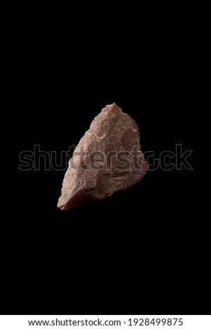 Beautiful paleolithic flint scraper in perfect condition on a black background. Soft hammed. Lower Palaeolithic