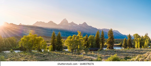 Beautiful panorama of the sunset over the grand tetons mountain range in the grand teton national park in summer at golden hour. Sunset / sunrise over the mountain range