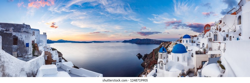 Beautiful panorama view of Oia village on Santorini island in Greece at sunrise with dramatic sky. 