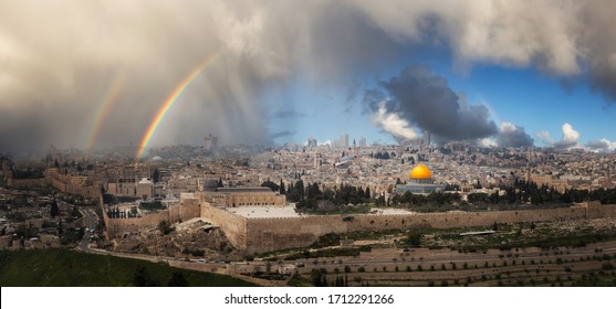Beautiful panoramic aerial view of the Old City, Tomb of the Prophets and Dome of the Rock. Dramatic Rain and Rainbow Sky Composite. Jerusalem, Capital of Israel.