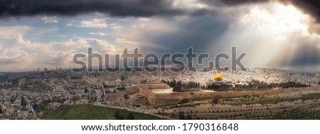 Beautiful panoramic aerial view of the Old City, Tomb of the Prophets and Dome of the Rock. Dramatic Sky with Sunrays Composite. Jerusalem, Capital of Israel.