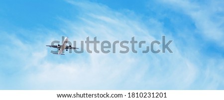 Beautiful Panoramic Background with flying plane in blue sky. Passenger airplane with landing gear released takes off in sky. Travel concept. Wide Angle Wallpaper or Web banner With Copy Space