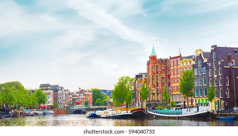 Beautiful Panoramic Cityscape Of Amsterdam, Capital Of Netherlands. Colorful View Of The Canal With An Amazing Building In Summer. Horizontal Image.