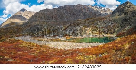 Beautiful panoramic view of the autumn misty valley. View from high mountain on picturesque landscape. Colorful nature, clear lake, stone river and yellow dried grass, environment. 