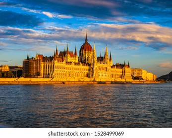 Beautiful Panoramic View Of Budapest With Parliament And The Danube Embankment From The Cruise Boat At Sunset